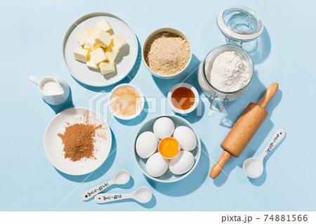 Cooking baking background with ingredients, butter, flour, eggs, spices and utensils on blue background 74881566