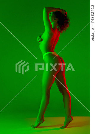 Beautiful female body on green background in neon light. Beauty, cosmetics, spa, depilation, diet and treatment, fitness concept. Beautiful female body on green background in neon light. Beauty, cosmetics, spa, depilation, diet and treatment, fitness concept. 74882412