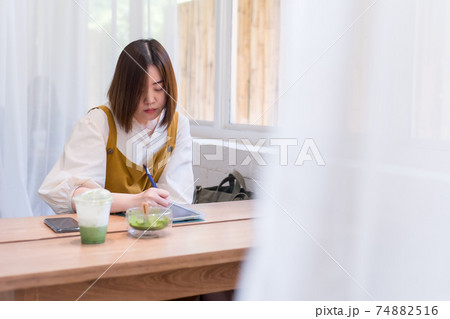 asian freelance woman use digital tablet for online work from coffee shop 74882516