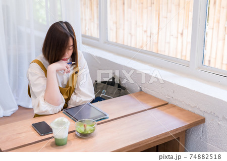 asian freelance woman use digital tablet for online work from coffee shop 74882518