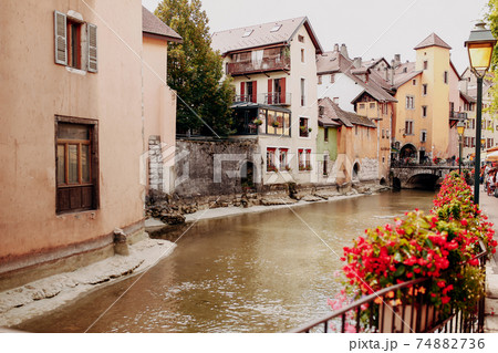 Annecy city water channel with red flowers and old buildings 74882736