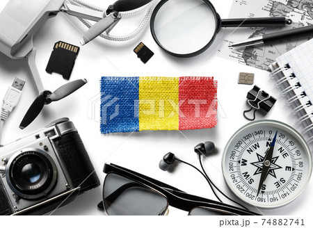 Flag of Romania and travel accessories on a white background. Flag of Romania and travel accessories on a white background. 74882741