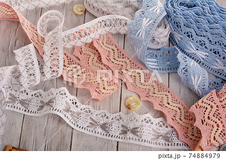 Pile of vintage cotton tapes and round buttons on wood background 74884979