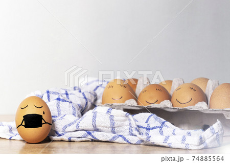 Creative Easter eggs with Corona virus protection, egg in a black mask in a quarantine. Diverse chicken eggs with smile on grey background. Flat lay, top view, mockup, copy space. 74885564