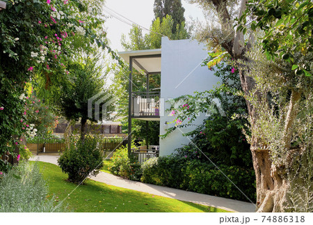 The territory of the hotel in the resort town with an incredibly beautiful garden, beautiful flowering shrubs and fruit trees. The building on the territory of the hotel, the concept of recreation The territory of the hotel in the resort town with an incredibly beautiful garden, beautiful flowering shrubs and fruit trees. The building on the territory of the hotel, the concept of recreation 74886318