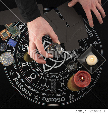 Hand holding a glass ball with horoscope reflections. Hand holding a glass ball with horoscope reflections. 74886484