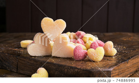 Gnocchi and Parmesan. Traditional Italian pasta with heart-shaped potatoes in different colors Gnocchi and Parmesan. Traditional Italian pasta with heart-shaped potatoes in different colors 74886995