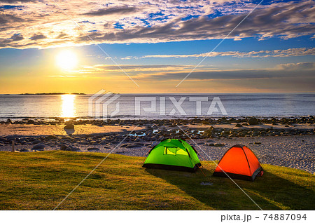Camping at sunset with tents on Uttakleiv beach in Lofoten islands, Norway 74887094