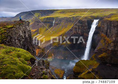 Hiker standing at the edge of the Haifoss waterfall in Iceland Hiker standing at the edge of the Haifoss waterfall in Iceland 74887109