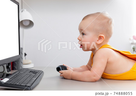 Caucasian funny little baby boy exploring computer, monitor and keyboard 74888055