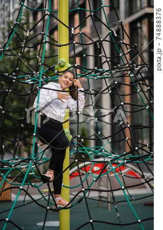 Young woman having fun on the rope pyramid 74888376