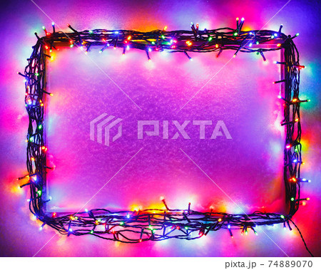 Christmas lights frame on snow background, purple color Christmas lights frame on snow background, purple color 74889070