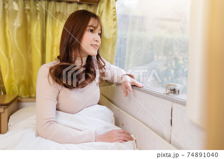 happy woman looking view at window of a camper RV van motorhome happy woman looking view at window of a camper RV van motorhome 74891040