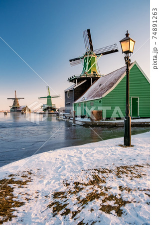 snow covered windmill village in the Zaanse...の写真素材 [74891263