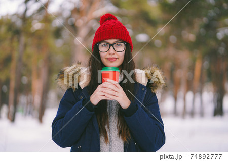 Girl in red hat with red paper cup in the forest Girl in red hat with red paper cup in the forest 74892777