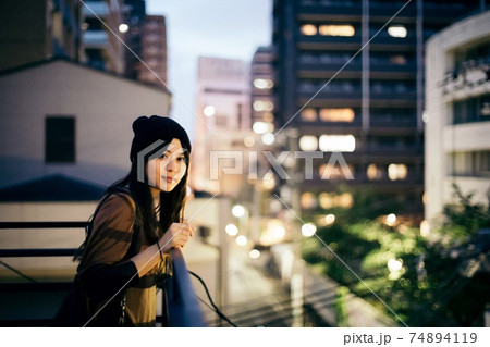 屋上にて　夜景とニット帽の女性 74894119