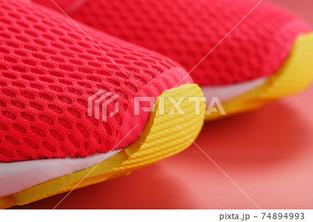 Jogging pink sneakers on a pink background with free space. Jogging pink sneakers on a pink background with free space. 74894993