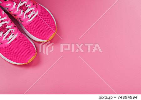 Sports pink sneakers on a pink background with free space. Sports pink sneakers on a pink background with free space. 74894994