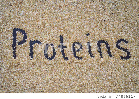 Quinoa on a black background and an inscription with a finger - proteins 74896117