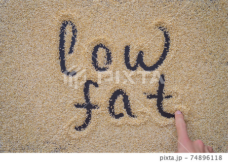 Quinoa on a black background and an inscription with a finger - low fat 74896118