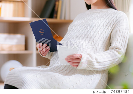 招待状を受け取る妊婦 招待状を受け取る妊婦 74897484