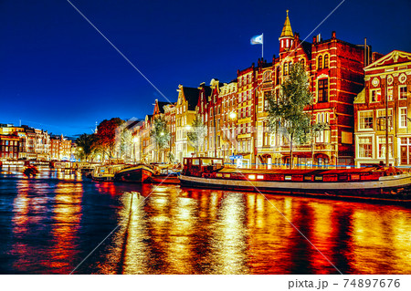 Famous Amstel river and night view of beautiful Amsterdam city. Netherlands 74897676