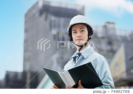 建設現場に立つ作業服の男性 74902709