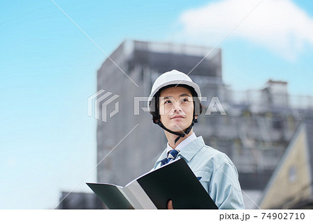 建設現場に立つ作業服の男性 建設現場に立つ作業服の男性 74902710