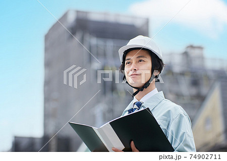 建設現場に立つ作業服の男性 建設現場に立つ作業服の男性 74902711