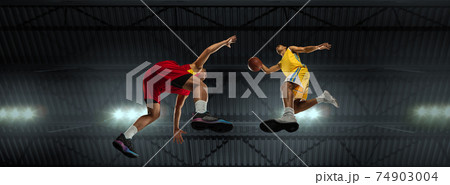 Young basketball players in competitive fight, motion in flight on black background, look from the bottom. Concept of sport, movement, energy and dynamic. 74903004