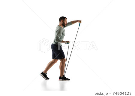 Young caucasian male model in action, motion isolated on white background. Concept of sport, movement, energy and dynamic, healthy lifestyle. Training, practicing. 74904125