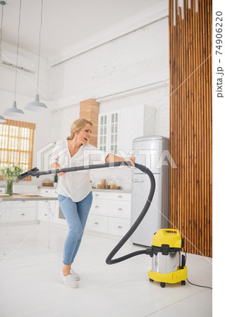 Woman having fun while cleaning house Woman having fun while cleaning house 74906220