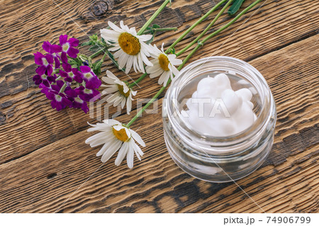 Cosmetic cream, fresh chamomile and verbena flowers on wooden background. Cosmetic cream, fresh chamomile and verbena flowers on wooden background. 74906799