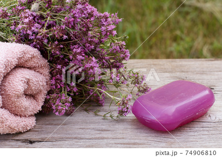 Towel with thyme flowers and soap on wooden background. 74906810