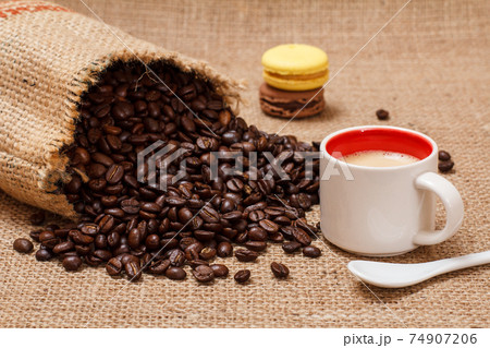 Cup of coffee and roasted coffee beans in a canvas sack. Cup of coffee and roasted coffee beans in a canvas sack. 74907206