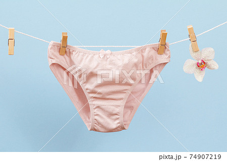 Beautiful women's cotton panties on blue background. Beautiful women's cotton panties on blue background. 74907219