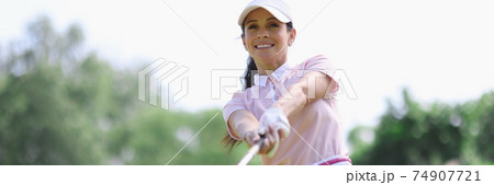 Woman golfer with putter in hand after hitting. 74907721