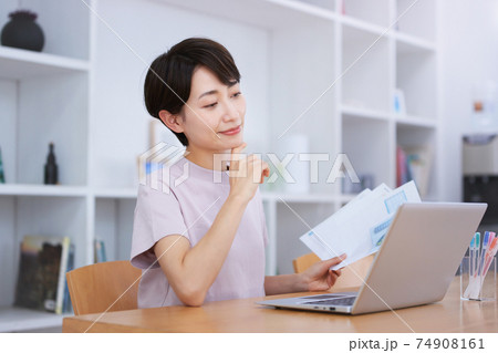 リビングでオンラインミーティングをするミドル女性 74908161