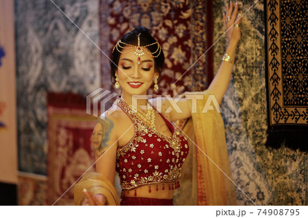Portrait of beautiful indian girl . Young hindu woman model in sari and kundan jewelry . Traditional India costume lehenga choli . Eastern or Arabic culture. 74908795