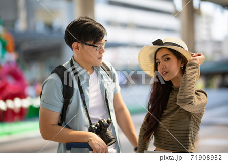 Asian couple enjoy travelling and walking on the street in city. Asian couple enjoy travelling and walking on the street in city. 74908932