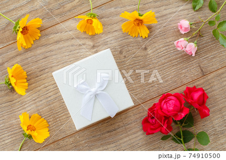 Gift box with flowers on the wooden background. Gift box with flowers on the wooden background. 74910500
