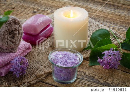 Towel, soap, candle and lilac flowers on wooden background. Towel, soap, candle and lilac flowers on wooden background. 74910631