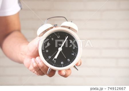 person hand holding alarm clock white background , 74912667