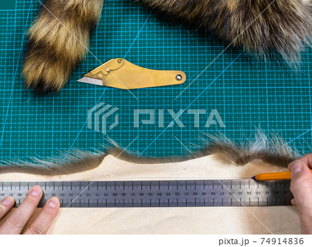 craftsman draws pattern on pelt with pen and ruler 74914836