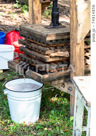 rural press and bucket with fresh apple juice rural press and bucket with fresh apple juice 74914856