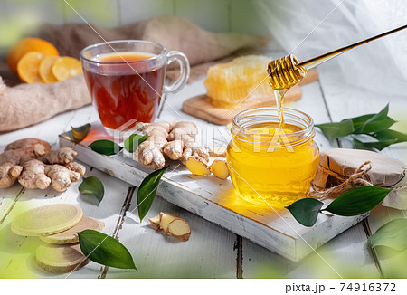 Still-life with honey and fresh tea in a transparent tea cup 74916372