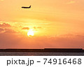 沖縄の夕日と飛行機と海 74916468