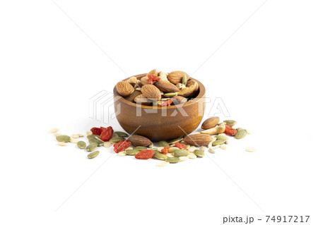 Assorted nuts are placed in a brown wooden cup on a white background with almonds, sunflower seeds, melon seeds, cashews, seasoned kee. Assorted nuts are placed in a brown wooden cup on a white background with almonds, sunflower seeds, melon seeds, cashews, seasoned kee. 74917217