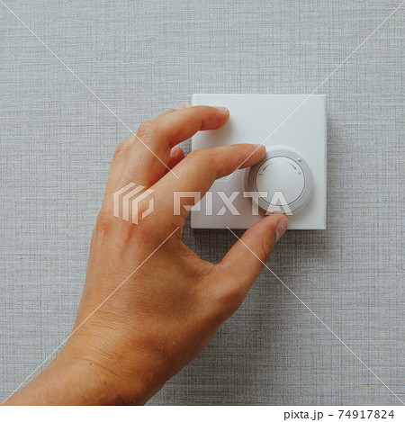 hand turning knob on thermostat climate control 74917824