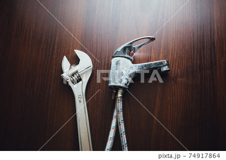 old faucet and adjustable wrench, plumbing repair concept old faucet and adjustable wrench, plumbing repair concept 74917864